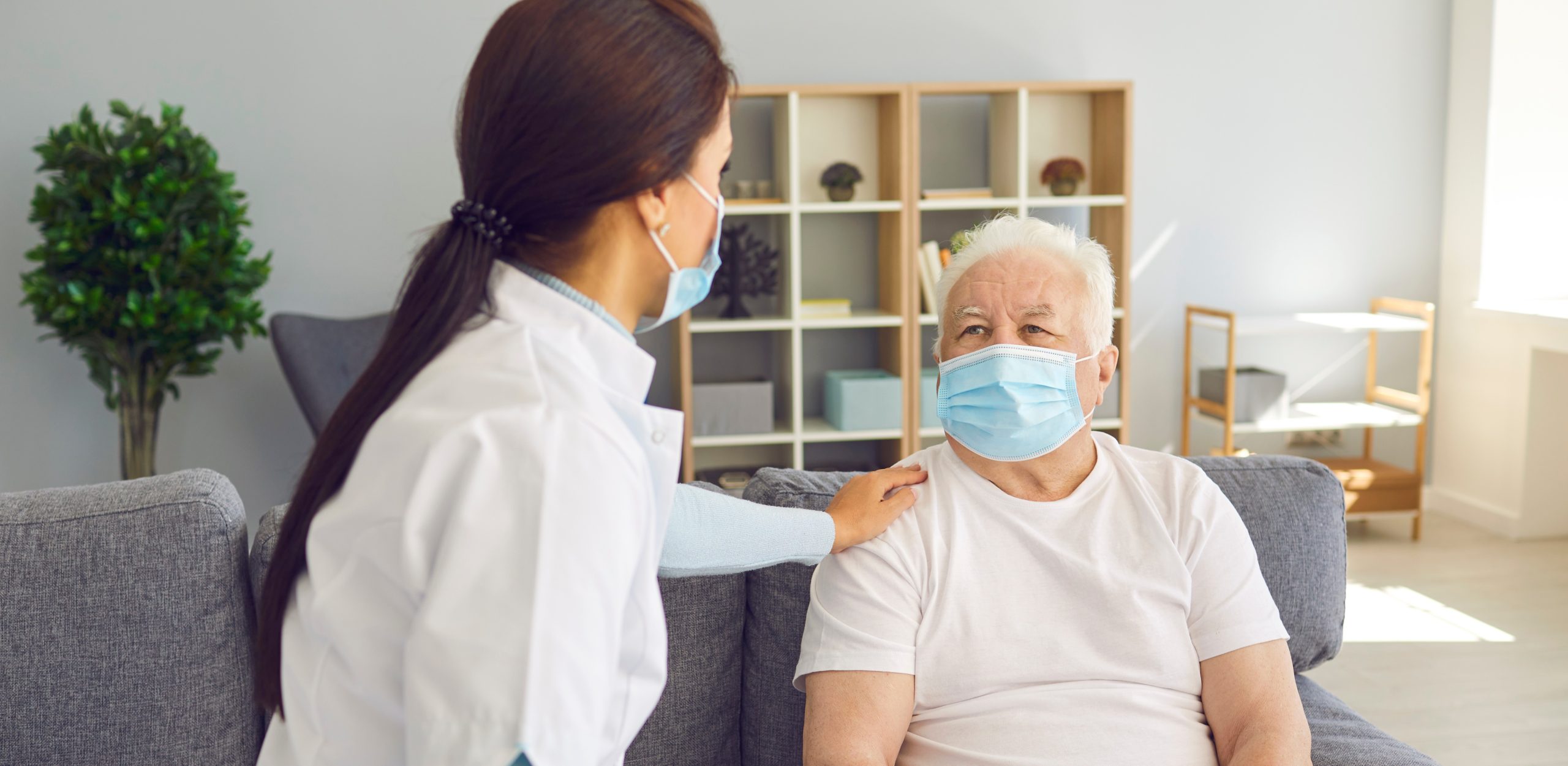 A masked man looking at his doctor
