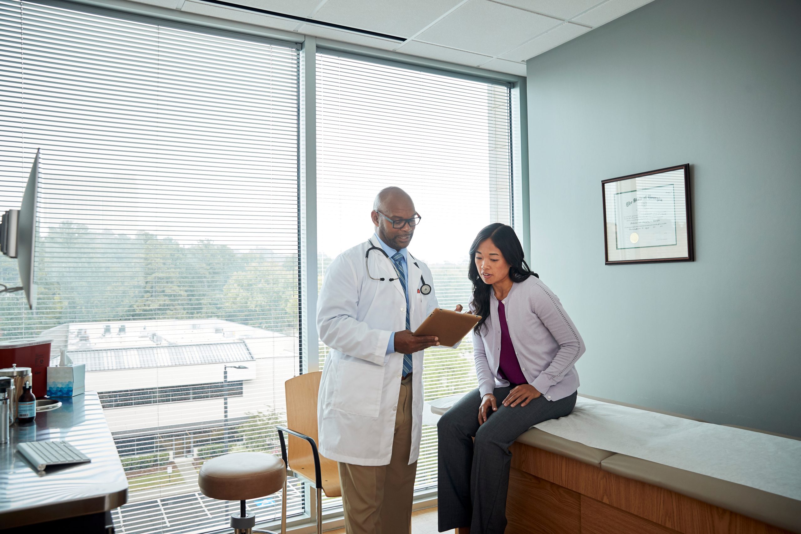 A medical provider reviewing a clipboard with a patient